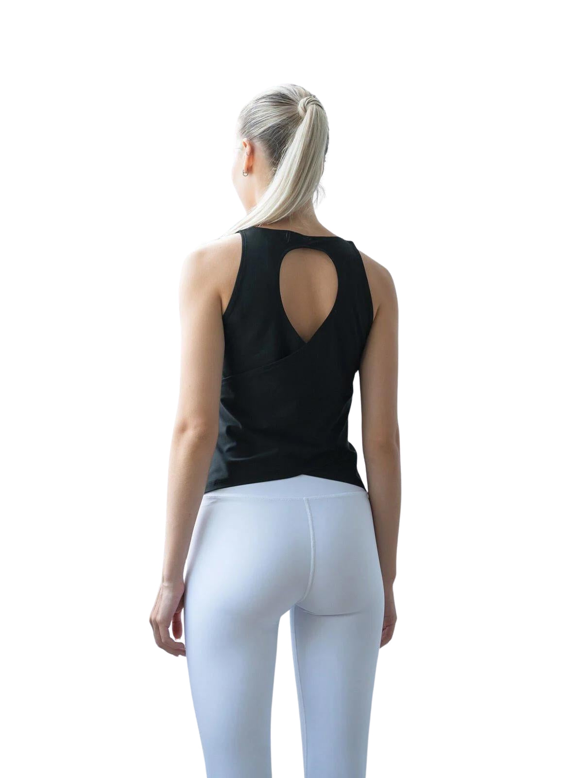 Person mit Pferdeschwanz in Lisminas 088 Sport-Top in Schwarz und weißen Leggings, die anmutig abgewandt ist.